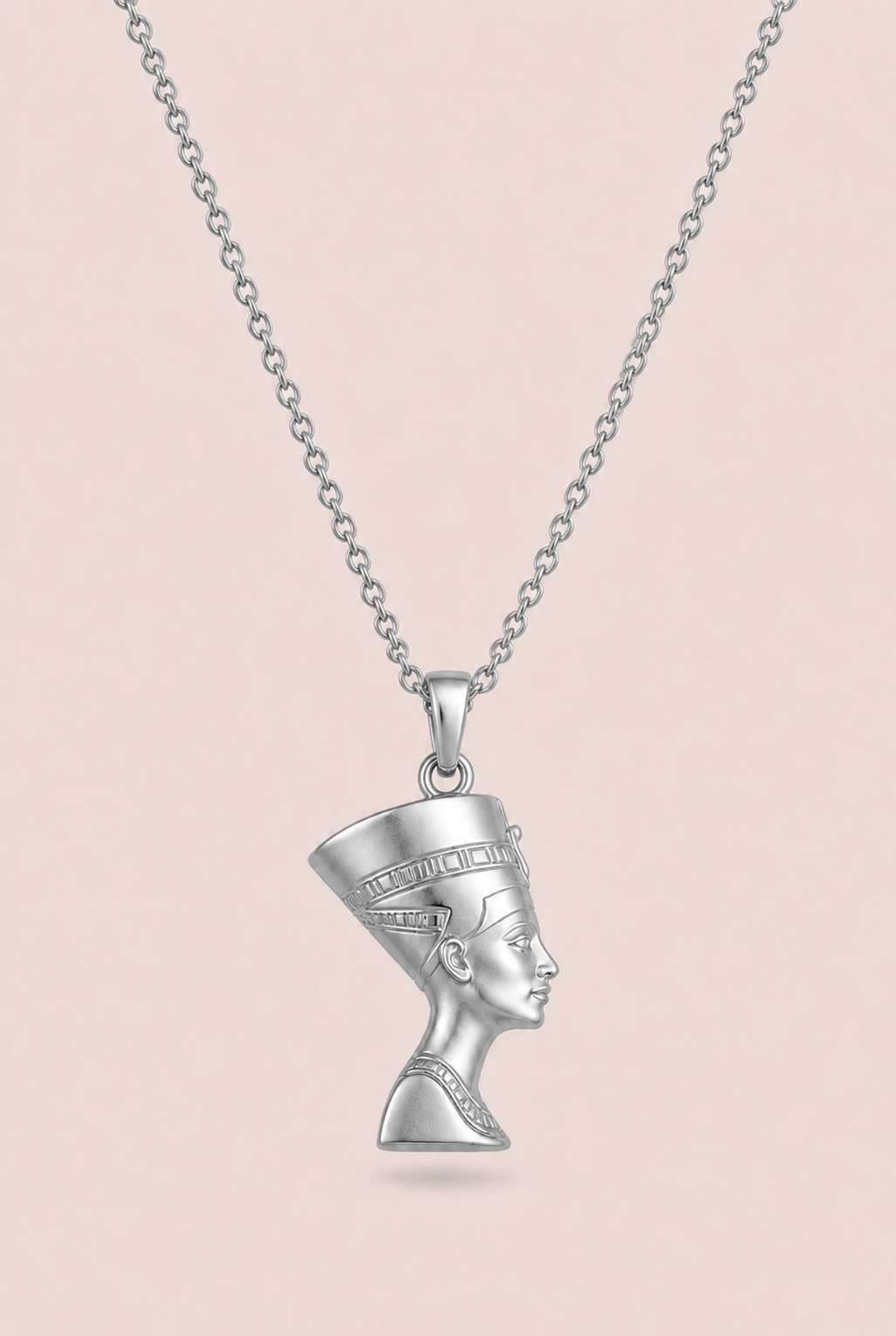 Silver necklace with a pendant of a woman's face on a beige background